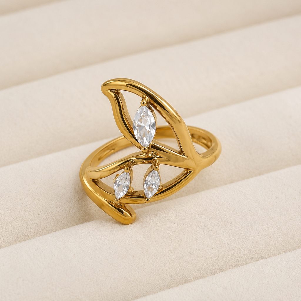Anillo Nerisa dorado con diseño de olas y detalles brillantes